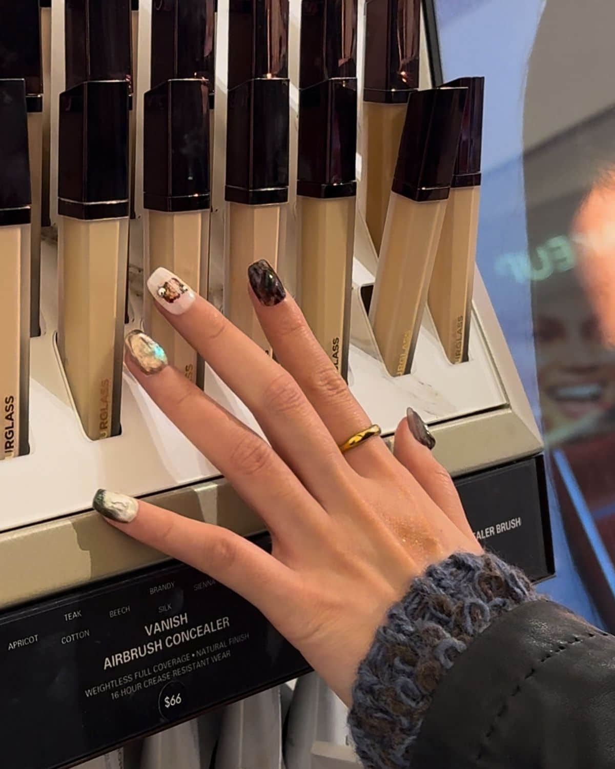 Press-on nails styled with beauty products at makeup counter.